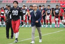 Hosomi caminha para o cointoss em jogo comemorativo de Kobe Ravens em outubro de 2025. (Foto: Kobe University)