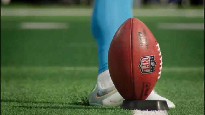 Bola da futebol americano posicionada para ser chutada