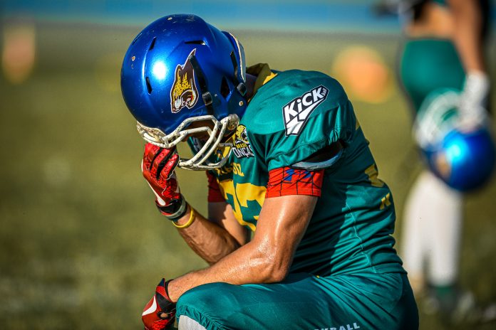 Heron Azevedo, jogador de futebol americano da Seleção Brasileira, ajoelhado