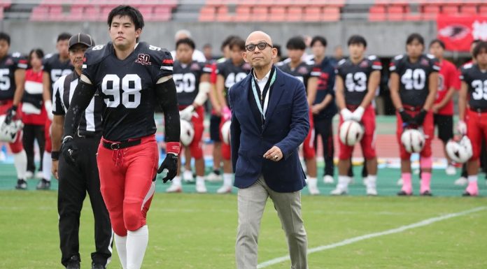 Hosomi caminha para o cointoss em jogo comemorativo de Kobe Ravens em outubro de 2025. (Foto: Kobe University)