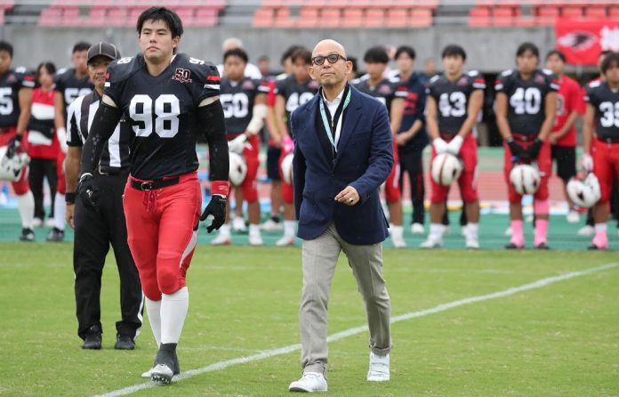 Hosomi caminha para o cointoss em jogo comemorativo de Kobe Ravens em outubro de 2025. (Foto: Kobe University)