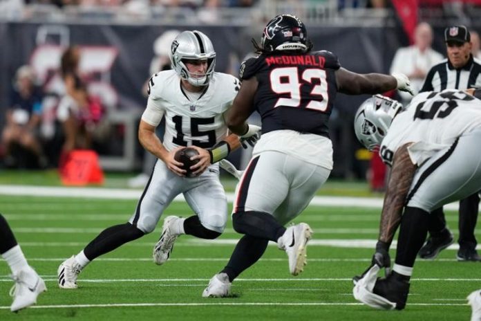 Fernando Mendoza (#15), é pressionado pelo defensive tackle do Houston Texans, Kayden McDonald (#93), durante o primeiro tempo do jogo de pré-temporada da NFL, nesta quinta-feira, 20 de agosto de 2026, em Houston. (Foto: David J. Phillip)