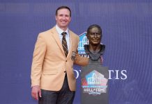 8 de agosto de 2026; Canton, Ohio, EUA; o integrante do Pro Football Hall of Fame, Drew Brees, posa com seu busto durante a cerimônia de inclusão da Classe de 2026, realizada no Tom Benson Hall of Fame Stadium. (Foto: Kirby Lee)
