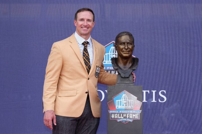 8 de agosto de 2026; Canton, Ohio, EUA; o integrante do Pro Football Hall of Fame, Drew Brees, posa com seu busto durante a cerimônia de inclusão da Classe de 2026, realizada no Tom Benson Hall of Fame Stadium. (Foto: Kirby Lee) 8 de agosto de 2026; Canton, Ohio, EUA; o integrante do Pro Football Hall of Fame, Drew Brees, posa com seu busto durante a cerimônia de inclusão da Classe de 2026, realizada no Tom Benson Hall of Fame Stadium. (Foto: Kirby Lee)