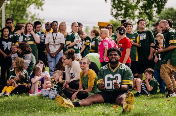 Jacob Monk, linha ofensiva dos Packers com familiares e alunos da Syble Hopp School, em De Pere, Wisconsin. (Foto: Keller Nienau)